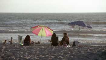 Beachgoers as the sun goes down